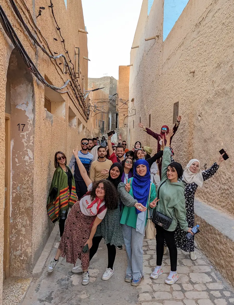 Des voyageurs allongés sur une dune au-dessus de Ghardaia au lever du soleil