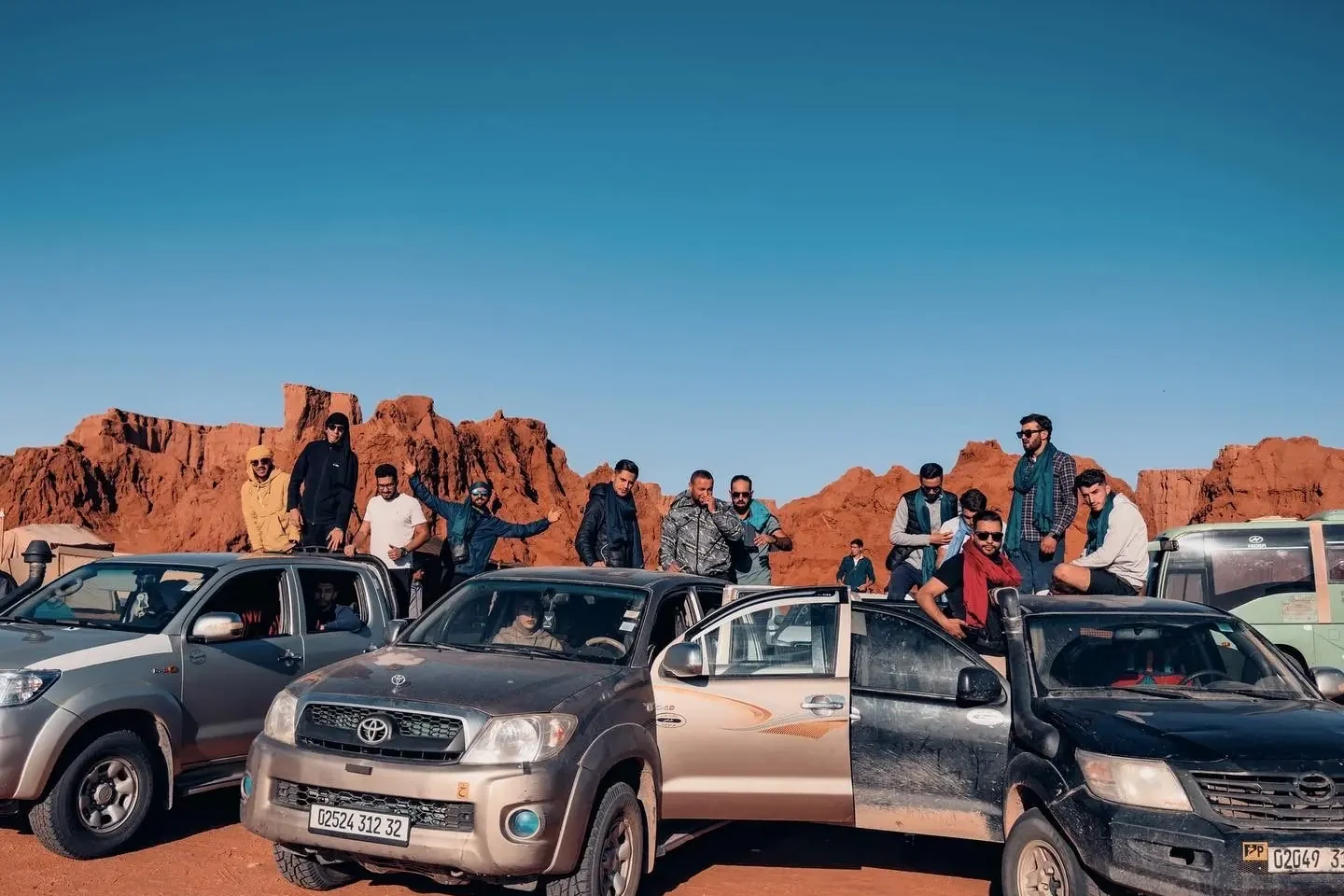 Des voyageurs Tourago sur leurs 4x4 parmi les roches rouges du Tadrart, près de Djanet