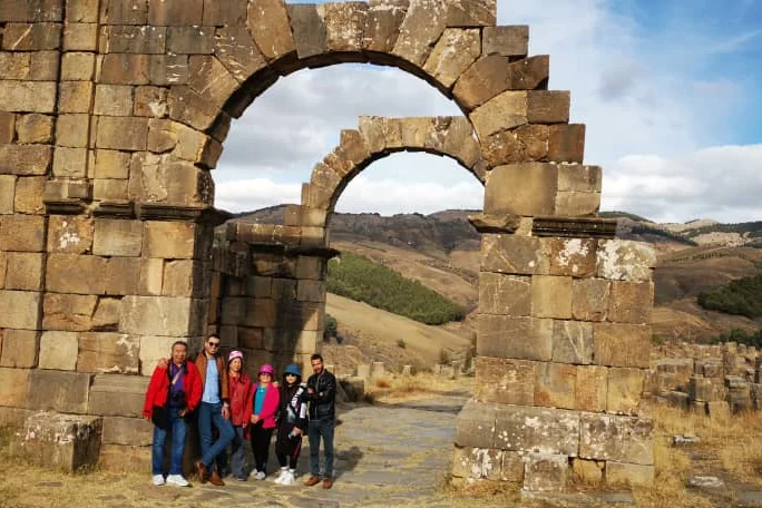 Un groupe Tourago devant l’arc de Caracalla à Djemila