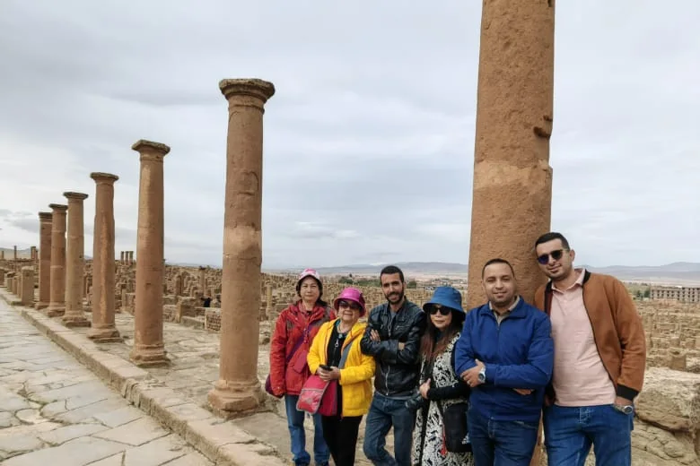 Un groupe Tourago parmi les colonnes de la voie principale de Timgad la romaine