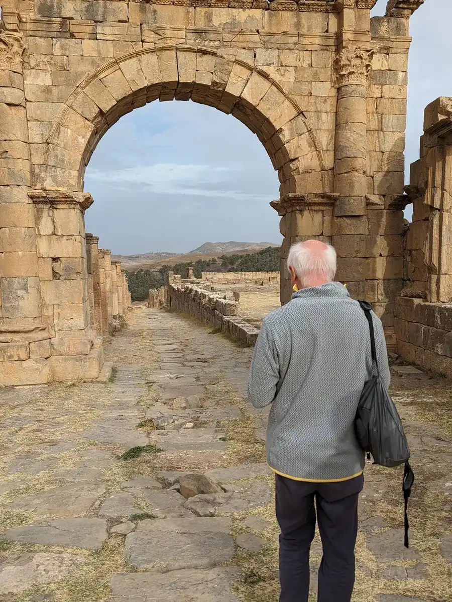 Une voyageuse passant sous l’arc de Caracalla à Djemila