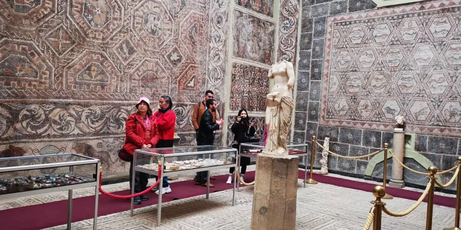 Podróżni w muzeum Cuicul w Djemili, wśród rzymskich mozaik na ścianach